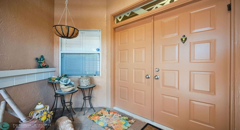 Lovely outdoor vestibule leads to double door entry to your home with designer atrium window above.