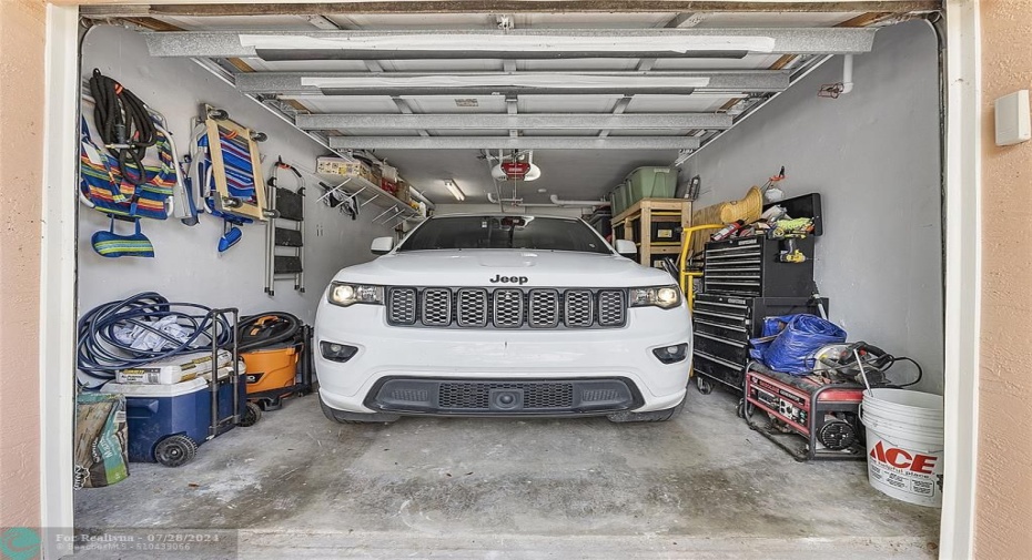 A large SUV can fit inside this garage with no trouble and still leave ample room on the sides for storage, Automatic garage door opener included.