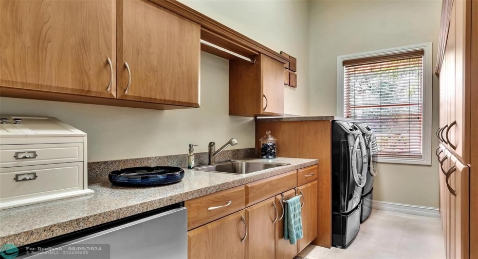 Laundry room with built in ironing board, mini fridge, and plenty of storage