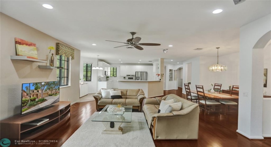 Light, bright, spacious family room with hi-hat lighting, ceiling fan, hardwood flooring.