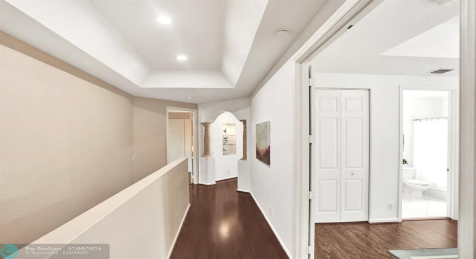 Passageway with hardwood flooring to 2nd guest suite with double door entry, large walk-in closet and bathroom ensuite.