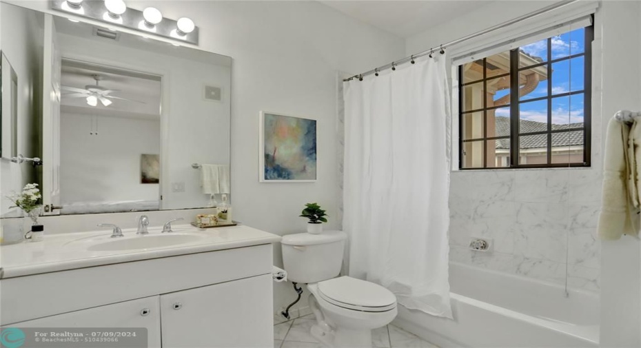 White on white ensuite full bathroom with tub/shower.