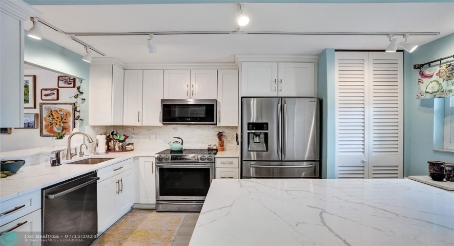 Open, bright kitchen with stainless steel appliances, lots of room to work and a water filtration system. Washer and dryer behind closet doors.