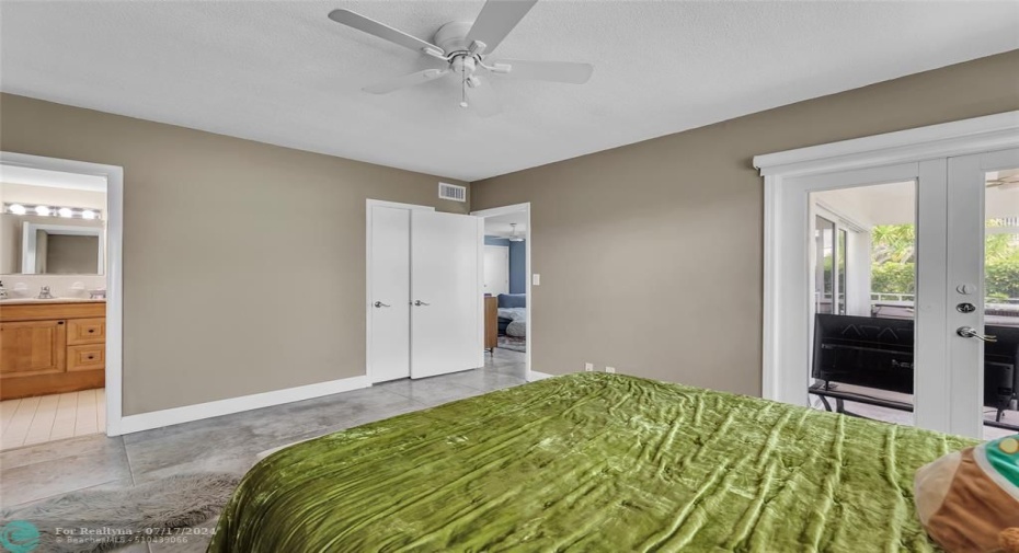 Spacious master bedroom with IMPACT french doors leading out to the screened patio.