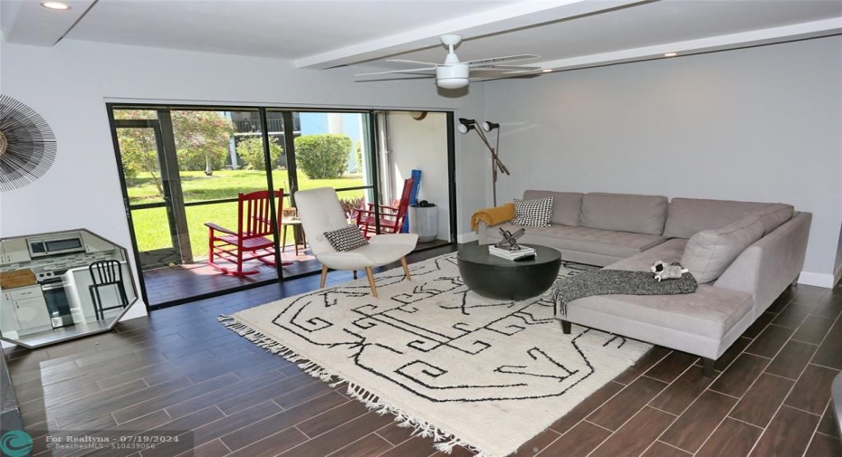 living room with plank tile and triple sliding doors