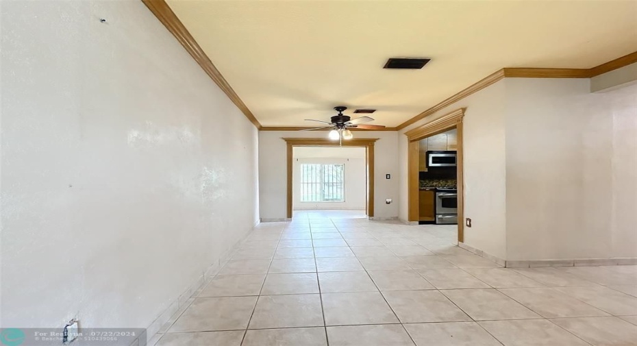Open living dining room with tile & crown molding.