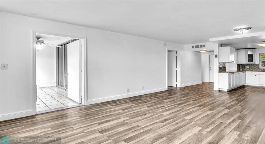 Living/Dining Area with entrances to Florida Room on left, Bedroom in center and open Kitchen on right