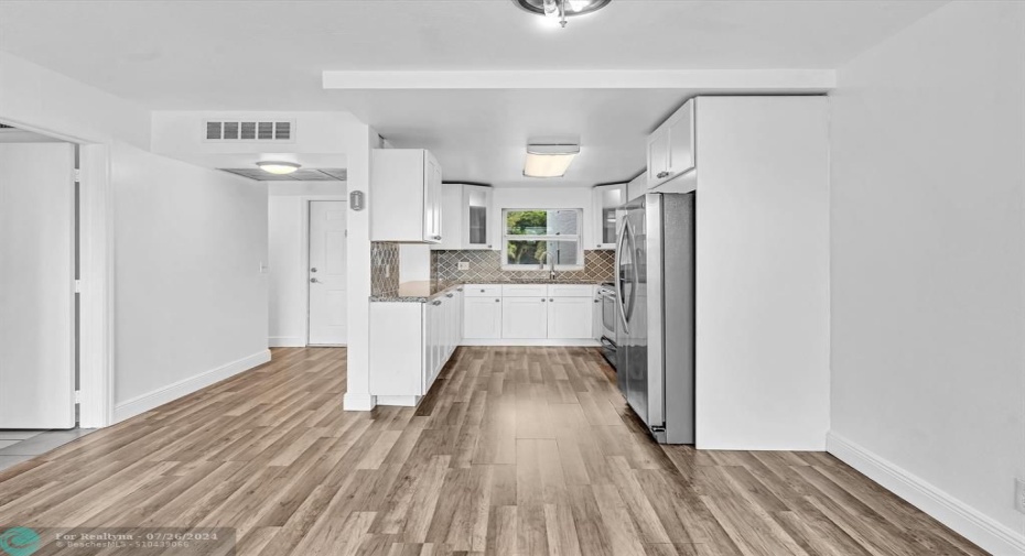 Dining Area with Bathroom entrance on left, Foyer Entrance in center, Open Kitchen on right.