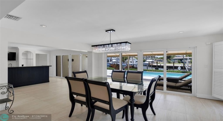 Dining room features sliders to pool and offers pool and water views