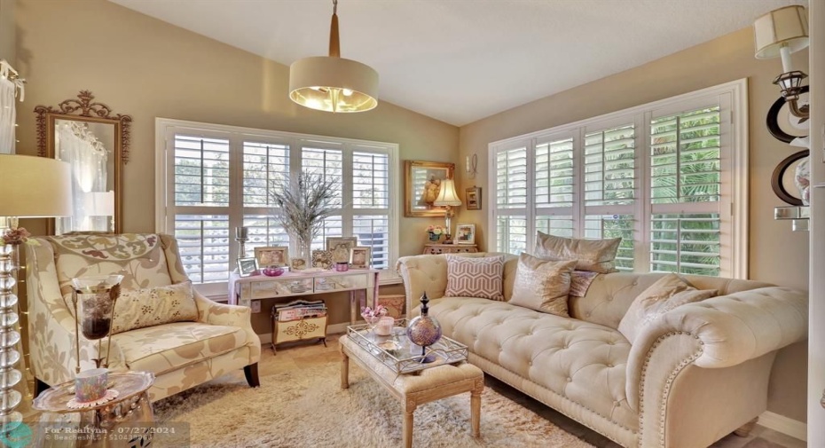 Primary bedroom sitting room with custom wood shutters. Could also be used as a home gym space, office, nursery.