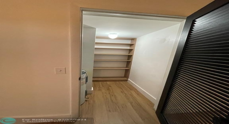 Pantry under the stairs for additional storage - built in shelving