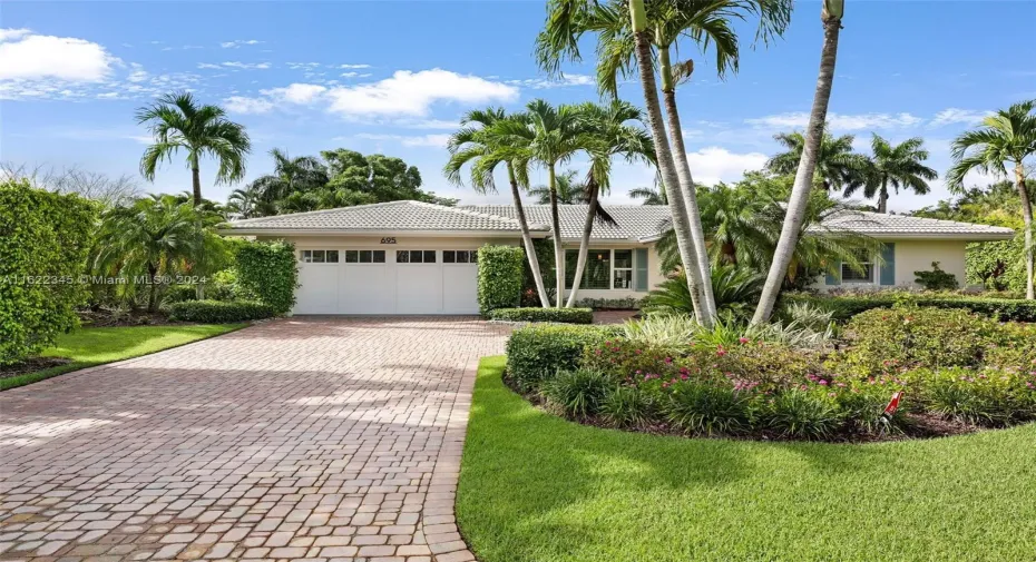 Brick paver drive, picture windows, lush landscaping