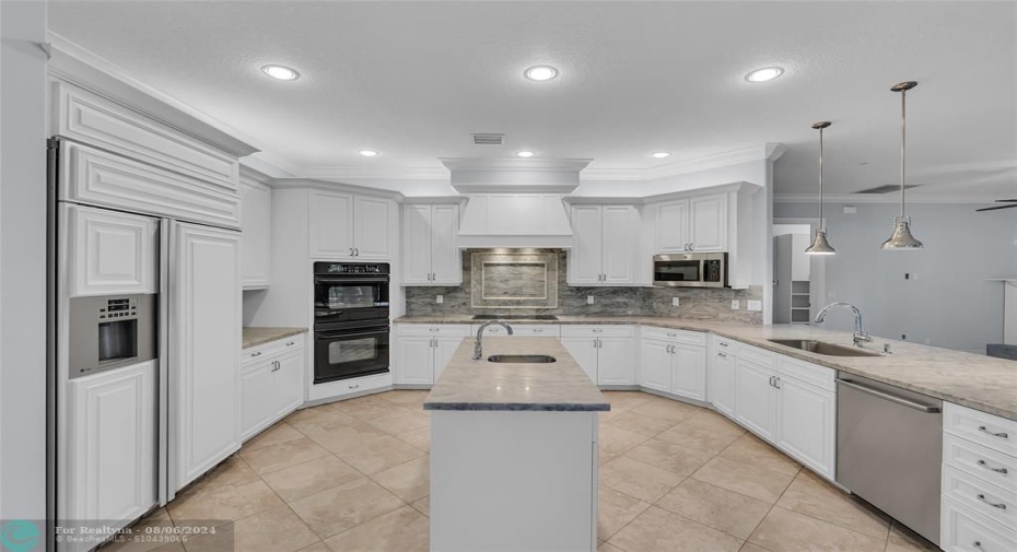 Spacious updated kitchen with Carrera marble counters, White cabinets, prep island with sink, double oven breakfast bar and more!