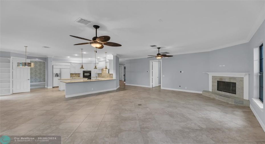 Family room features a fireplace with marble mantle and breakfast bar shared with kitchen