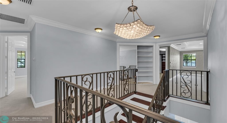 Second floor with gorgeous lighting and open railing staircase with storage closet offered in hallway