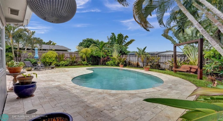 Pool deck with wood bench.