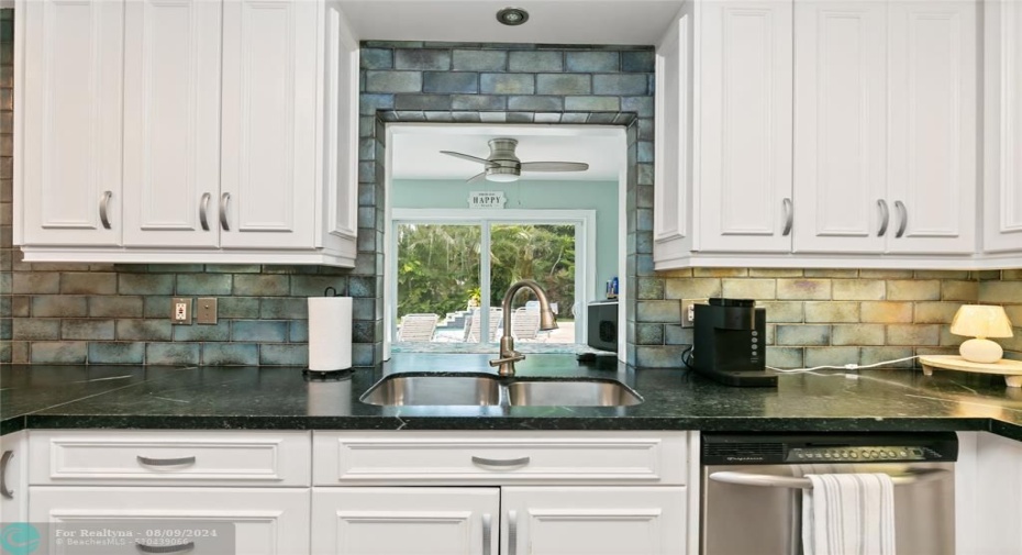 Kitchen with view of pool deck in background