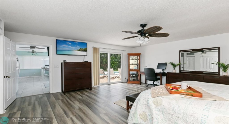 Guest bedroom with impact slider leads out to pool deck