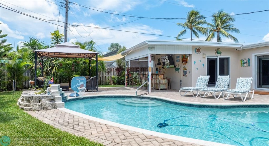 Outdoor living space with saltwater pool. Covered area set up with TV & bar for entertaining with gazebo to the side for relaxing