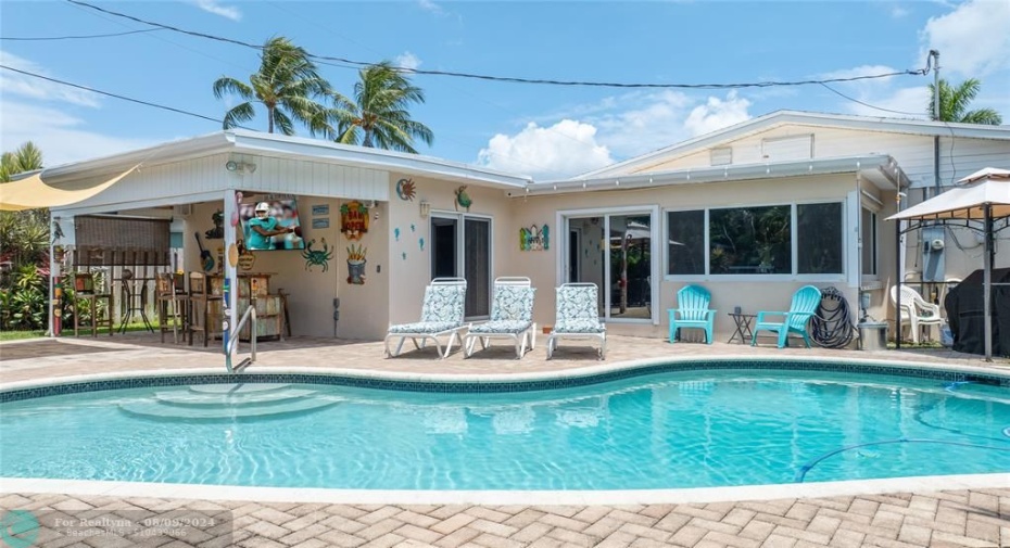 Outdoor living with saltwater pool with paver deck, covered TV area, also gazebo area to left just outside of this photo and a BBQ area to the left just outside of this photo. See in photos to come