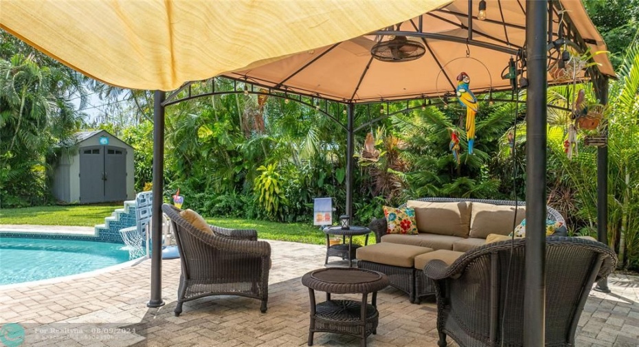 Gazebo surrounded by lush landscape. Shed in background stays with property