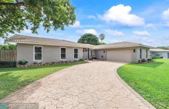 The front view of the home reveals an expansive driveway, perfect for accommodating multiple vehicles