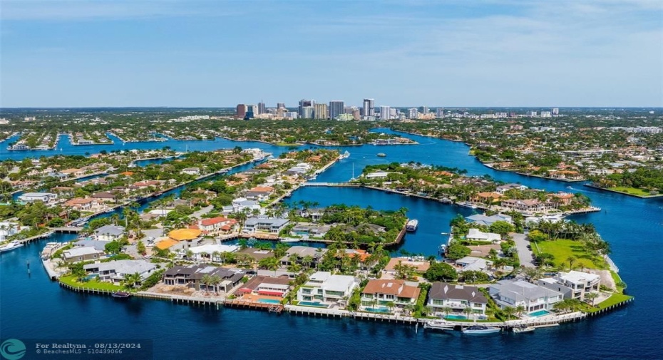 White home centered with backyard facing water. Views of Downtown Fort Lauderdale