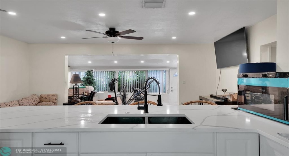 Looking past the living room to the Florida Room.  Recessed LED lighting and ceiling fan.