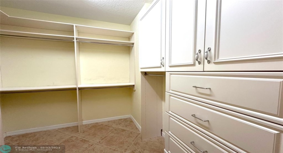 Custom Built-in in 1 of 2 walk in closets in Primary Bedroom