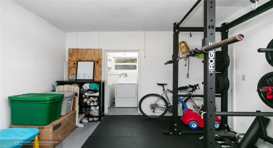 Garage with laundry room in background and impact large door, side door & window. What a great space for your car or as it is set up for a great workout or whatever you envision.