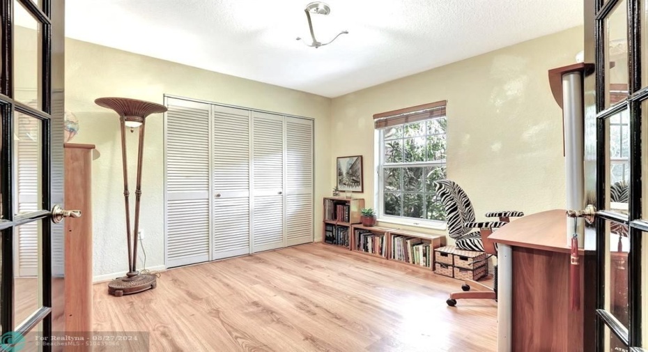 This den with closets has wood lam flooring and is perfect as an office or 3rd bedroom.