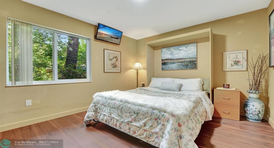 Bedroom #2 with custom  Murphy bed, wood floors, impact glass windows.