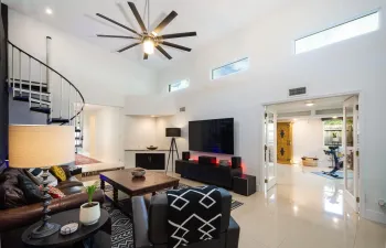 living room with spiral stairs to the loft