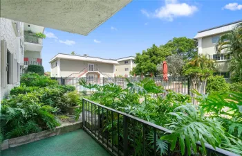 Private porch with lush foliage opposite pool area