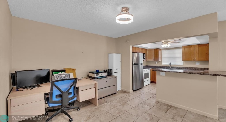 Dining room and kitchen share a breakfast bar and offer tile flooring