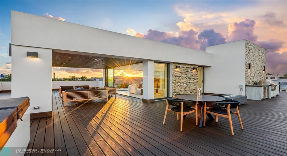 Outside sitting area on the third level with outdoor kitchen, jacuzzi, and firepit.