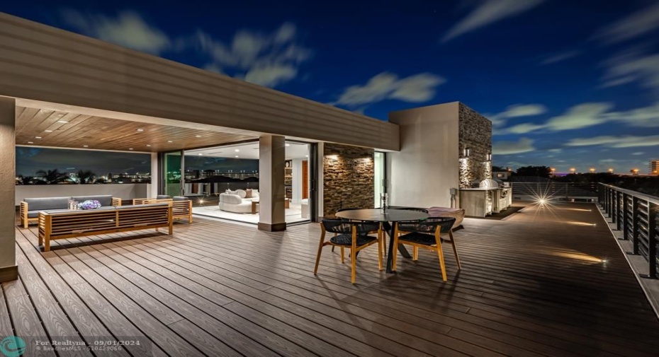 Outside sitting area on the third level with outdoor kitchen, jacuzzi, and firepit.