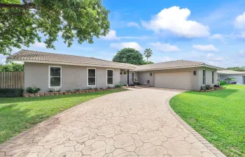 The front view of the home reveals an expansive driveway, perfect for accommodating multiple vehicles