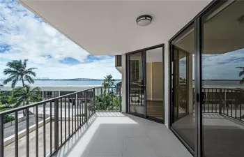 Living room balcony with views of Biscayne Bay, pool and tennis courts.