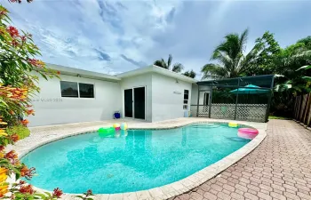 Lush backyard pool with screened patio