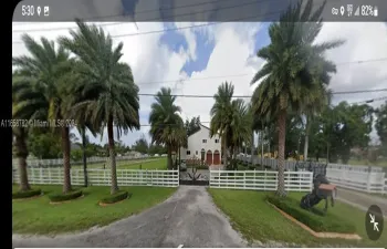 This elegant 6-bedroom, 6-bathroom estate boasts timeless charm with a spacious driveway, nestled on a 2-acre lot in Miramar, offering privacy and expansive outdoor space.