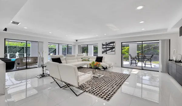 Double door entry into gorgeous living area featuring porcelian tile floors and smooth ceilings.