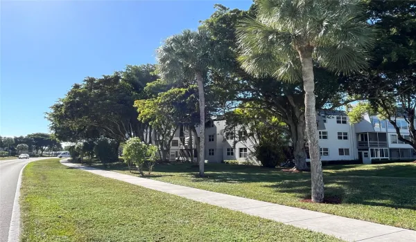 View of balconies surrounded by lush trees that cast shadows over the area, creating a sense of freshness and tranquility.