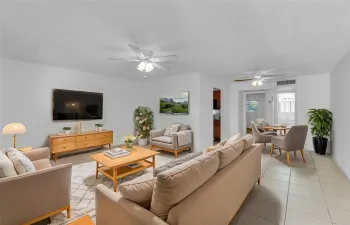 Large and spacious living room with tile flooring and overhead ceiling fans