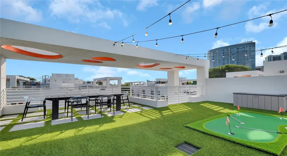 Amazing, turfed 1500sf private rooftop terrace with putting green, dining table, and corn hole