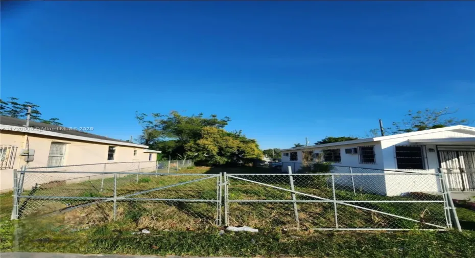 The Lot is in-between the Chain Link Fence. The Lot is 2,425 SQ FT.