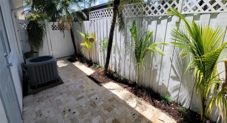 Priavate patio with travertine and palm trees.