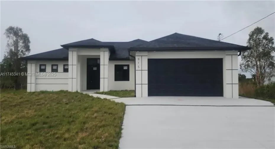 View of front façade with a garage and front lawn