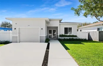 Front of home with large driveway, one car garage, covered entrance and fenced yard.