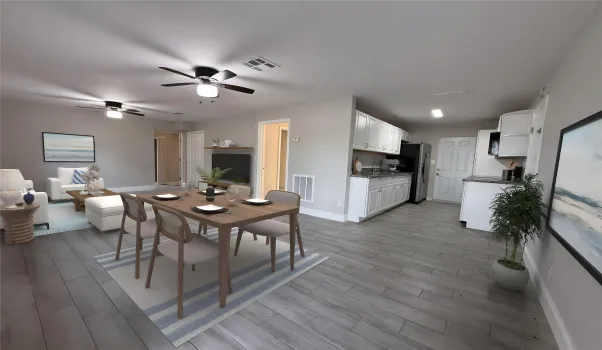 Professionally staged view showcasing the kitchen, dining area, and living room